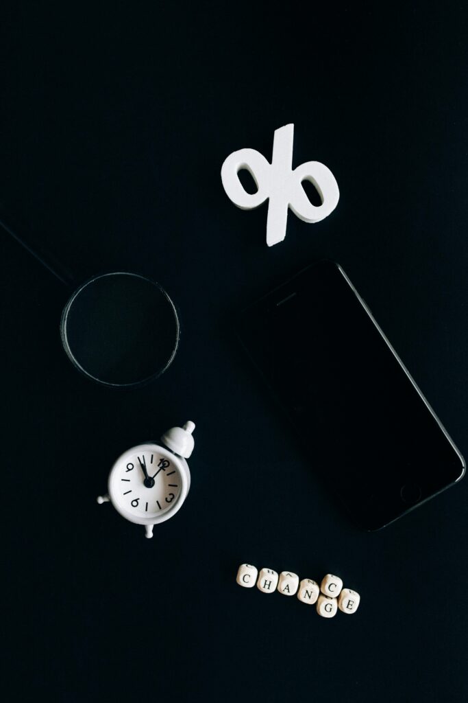 Stylish composition of clock, symbols, and text representing financial change on a dark background.